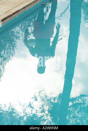 Mann, der vom Rand des Schwimmbades spiegelt sich in der Oberfläche des Wassers Stockfoto