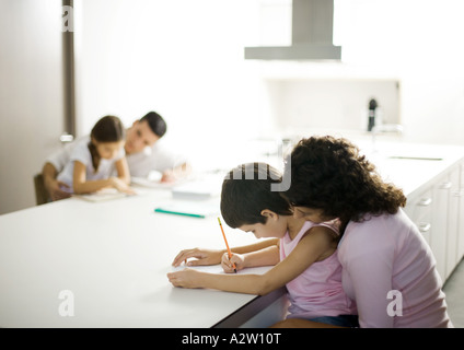 Eltern, die ihren Kindern bei den Hausaufgaben helfen Stockfoto