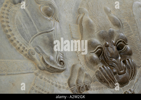 Eine wiederkehrende Basrelief zeigt einen Löwen beißen ein Einhorn in der Persepolis archäologische Stätte, in der Nähe von Shiraz, Iran. Stockfoto