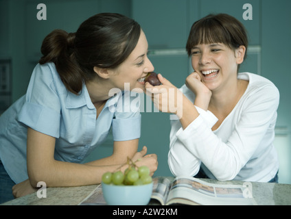 Verzehr von Obst aus der Hand Tochter Mutter Stockfoto