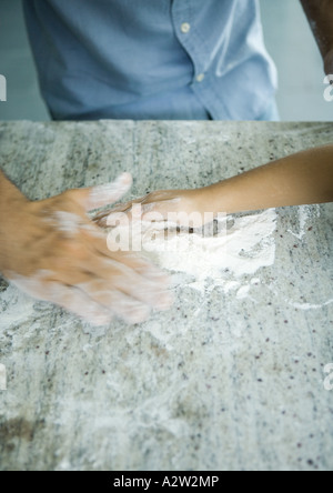 Vater und Tochter kochen zusammen, Hände in Mehl in Nahaufnahme Stockfoto