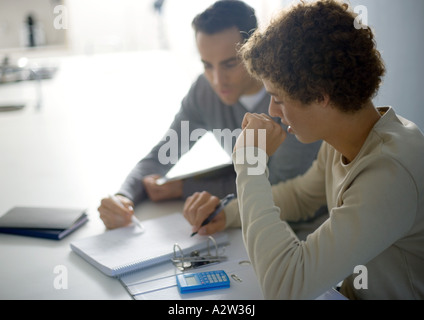 Vater Sohn im Teenageralter bei Hausaufgaben helfen Stockfoto