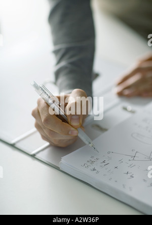 Person die Hand gestellt über Notebook mit Mathe-Noten Stockfoto