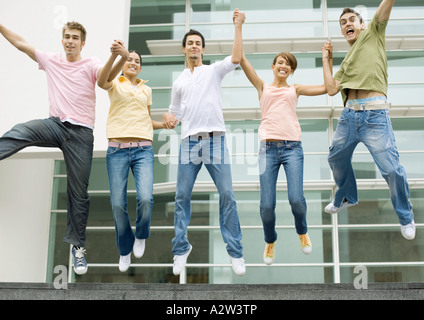 Teens Hand in Hand und in die Luft springen Stockfoto