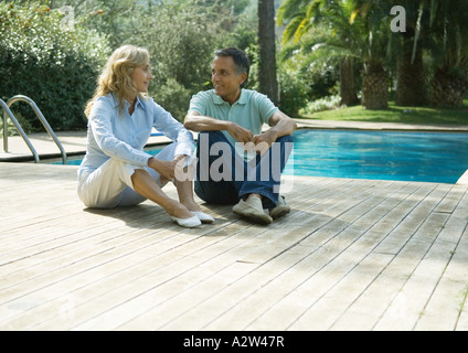 Älteres paar sitzen an Deck von Schwimmbad Stockfoto