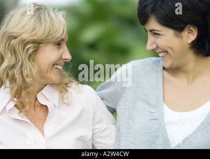 Reife Frau und Erwachsene Tochter, Lächeln einander an Stockfoto