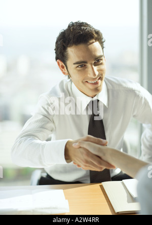 Mann Händeschütteln über Tisch Stockfoto