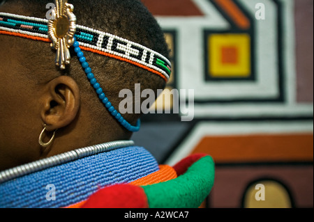 Ndebele Frau in Tracht gekleidet verheiratete Frau traditionelle geometrischen Wandmalereien im Hintergrund Südafrika Stockfoto