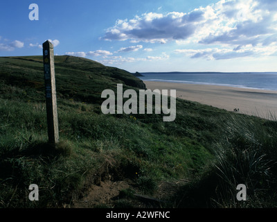 Ein Wanderweg-Zeichen an einem windigen Strand bei Newgale Sands entlang der Pembrokeshire Küste Stockfoto