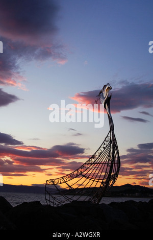 Das Nachleuchten der Sonnenuntergang hinter der Viking Longboat Skulptur in Largs marina Stockfoto