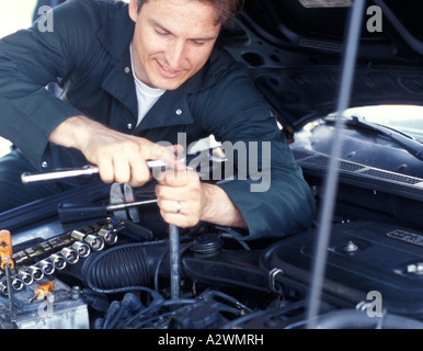 Junger Mann arbeiten am Motor Stockfoto