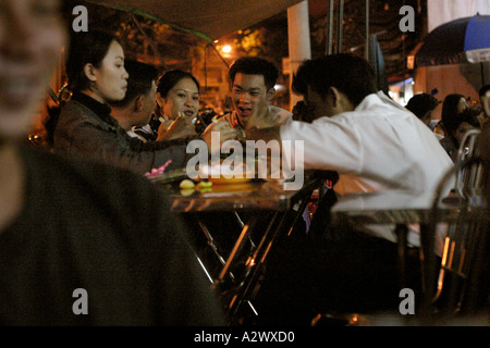 Junge Menschen, die Essen in einem Restaurant Pflaster in der Nacht, Saigon, Vietnam Stockfoto