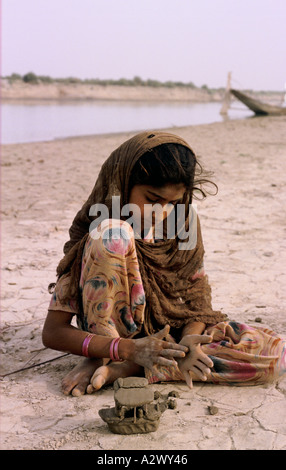 Eine junge sindhi Mädchen, Modelle der Boote von Indus Ton am Ufer des Sees Manchar, Pakistan. Stockfoto