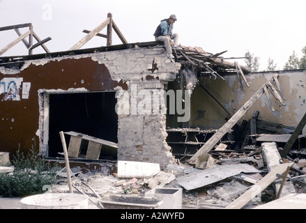 Vukovar, Kroatien, unter serbischer Kontrolle, Februar 1992: ein Mann lacht, als er zu retten, was er aus den Trümmern seines Hauses kann Stockfoto