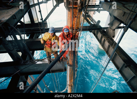 Hohe Sicht von zwei männlichen Ingenieure stehen auf Öl Bohrinsel nächste Welle zu bohren. Nordsee. UK. Stockfoto