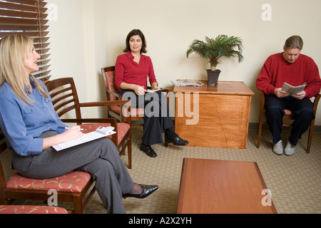 Patienten warten geduldig, lesen Zeitschriften und Patienteninformationen zu lesen. Stockfoto