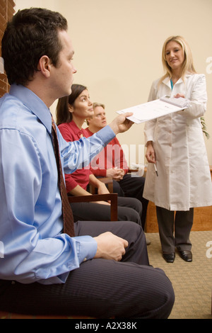 Krankenschwester sammelt Formen von Patienten im Wartezimmer. Stockfoto