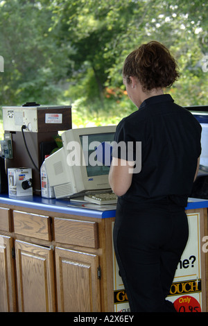 Weiblichen Techniker überprüft ihren Computer für einen Fahrzeug-Service-Datensatz in einer Garage. Stockfoto