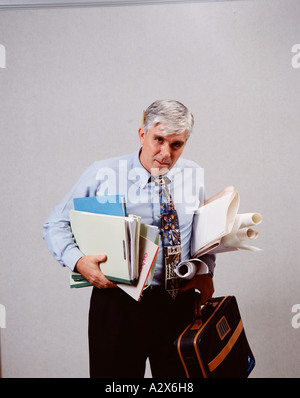 Applying Mann hält Papierkram und suchen Sie gestresst und überarbeitet. Stockfoto