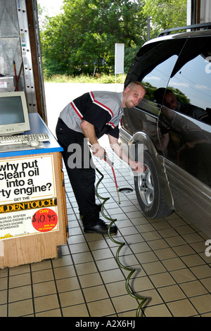 Männliche Fahrzeug Techniker überprüft den Reifendruck eines Fahrzeugs in einer schnellen Service Garage. Stockfoto