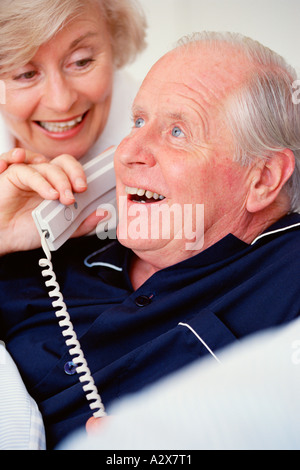 Ältere Mann und Frau im Innenbereich am Telefon zu sprechen. Stockfoto