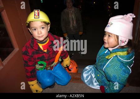 Halloween Trick oder Treaters asiatische Kinder in Kostümen wie Bob der Baumeister Alter 2 oder 3. St Paul Minnesota USA Stockfoto