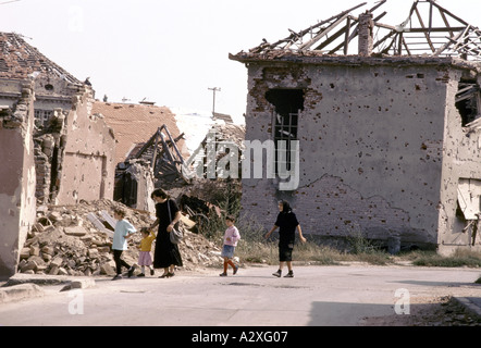 Vukovar, Kroatien, unter serbischer Kontrolle, Februar 1992: Frauen und Kinder zu Fuß durch den Schutt.  15.000 Menschen leben noch hier. Stockfoto