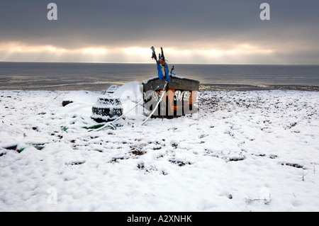 Schnee auf ein einsames Fischerboot und Hummer Töpfen auf Worthing Strand nach Winterstürme in Sussex und Kent in Südengland Stockfoto