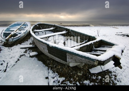 Schnee auf zwei Angelboote/Fischerboote am Strand von Worthing nach Winterstürme in Sussex und Kent in Südengland Stockfoto