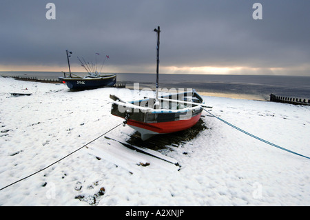 Schnee auf einem einsamen Fischerboot am Strand von Worthing nach Winterstürme in Sussex und Kent in Südengland Stockfoto