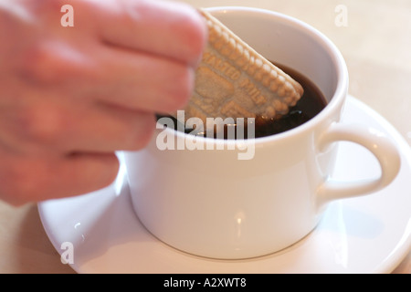 Dunking Keks in Tasse Kaffee Stockfoto