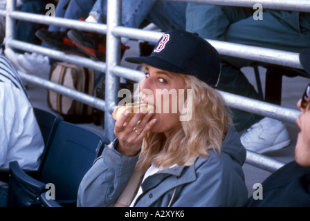 Mädchen essen Hot Dog bei Baseball-Spiel. Stockfoto