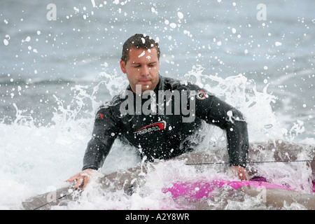 männlichen Kitesurfer im schwarzen Anzug wird von einer Welle getroffen, während im Wasser El Medano Strand Teneriffa Stockfoto