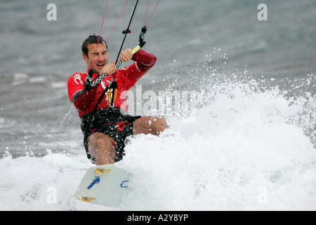 männliche Kitesurfer in rot wird durch eine Welle im Wasser Weg von El Medano Strand Teneriffa-Kanarische Inseln-Spanien getroffen. Stockfoto