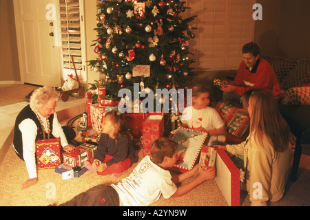 Familie und Freunde um Weihnachtsbaum zu Hause den Austausch von Geschenken Stockfoto