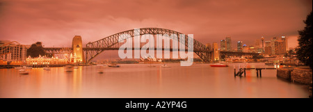 Skyline der Stadt mit der Sydney Harbour Bridge und Lunar Park (links) über Lavender Bay bei Sonnenuntergang Stockfoto