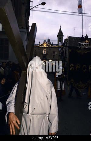 Malta-Teilnehmer tragen Gesicht Abdeckhaube mit Gewand mit großen Holzkreuz während Osterprozession 1986 Stockfoto