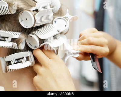 Friseur in Lockenwickler setzen Stockfoto