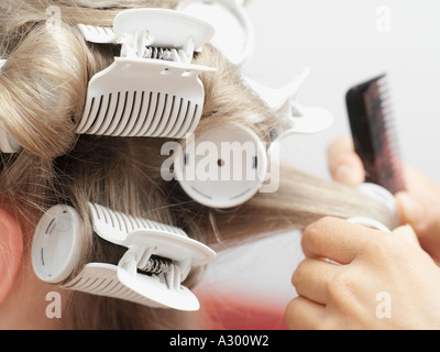 Friseur in Lockenwickler setzen Stockfoto