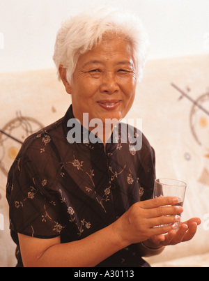 Chinesische Reife Frau mit einem Glas Wasser Stockfoto