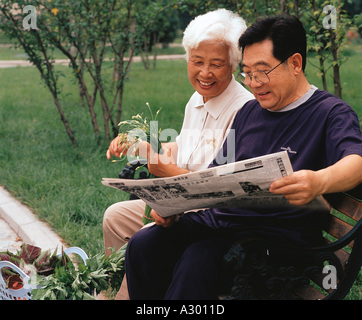 Chinesische glücklich älteres Paar auf einer Bank sitzend Stockfoto