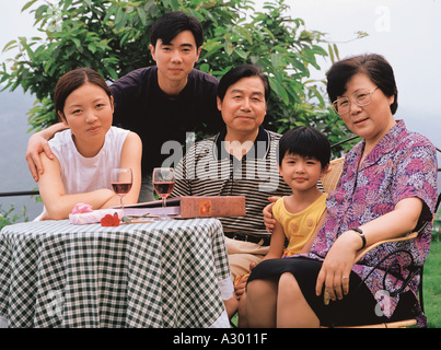 Chinesische Familie sitzen in einem Hof und betrachten von alten Fotos Stockfoto