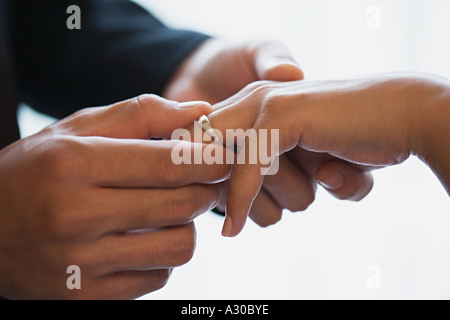 Bräutigam Hochzeit Ring auf Bräute Finger platzieren Stockfoto