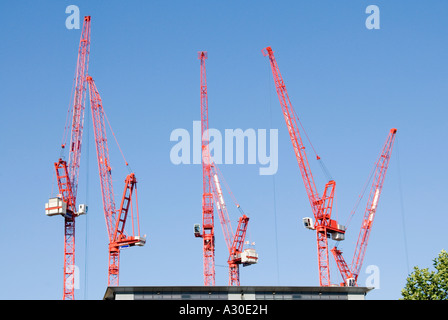 Gruppe von sechs roten Turmdrehkrane Bauindustrie Baustelle arbeiten an Material Handling für Erdarbeiten und Stiftungen unter London England Großbritannien Stockfoto