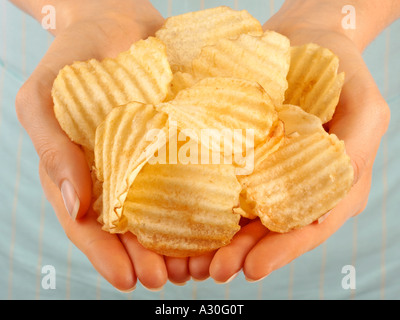 FRAU HOLDING CRINKLE GESCHNITTEN CHIPS / CHIPS Stockfoto