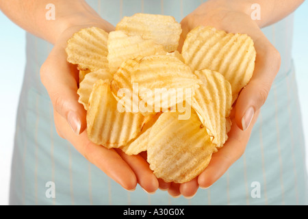 FRAU HOLDING CRINKLE GESCHNITTEN CHIPS / CHIPS Stockfoto