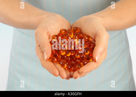 FRAU-HOLDING-VITAMIN-ÖL-KAPSELN Stockfoto