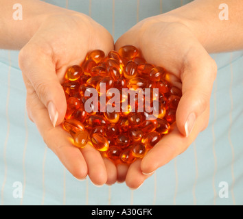 FRAU-HOLDING-VITAMIN-ÖL-KAPSELN Stockfoto