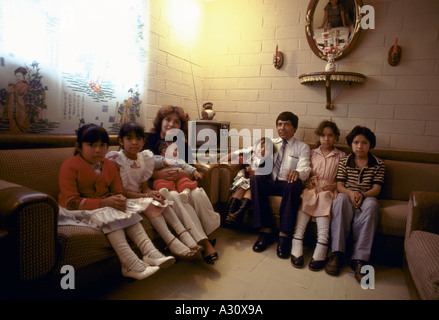 Mutter und Vater mit ihren sechs Kindern in ihrem Wohnzimmer Stockfoto