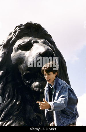 junge neben Löwenstatue in "Trafalgar Square" Stockfoto